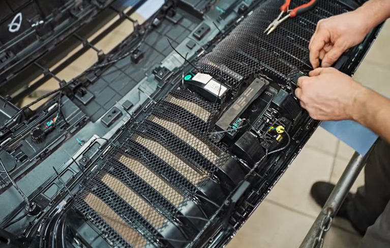 Процесс установки защитной сетки в решетку радиатора Джили